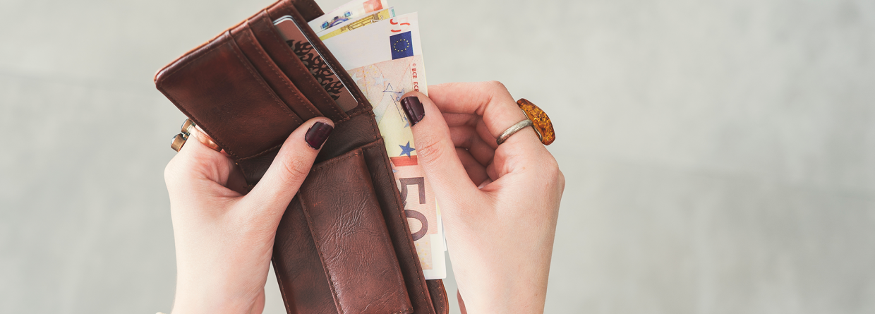 Prinsjesdag koopkracht; vrouw heeft een portomonnee in haar hand en haalt er briefgeld uit